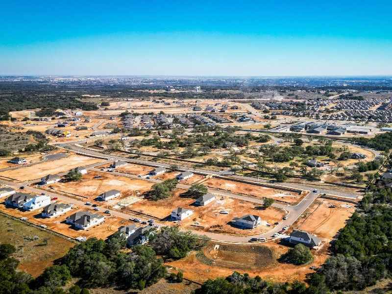 Aerial view of residential and commercial development in New Braunfels, Texas showing land parcels, road layouts, and areas relevant to land surveying and site planning
